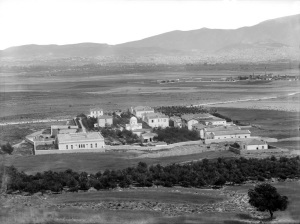 Γενική άποψη του Δρομοκαϊτείου στις αρχές του 20 αιώνα . Στο βάθος η μικρή τότε Αθήνα και ο χωματόδρομος που διασχίζει είναι η αρχέγονη